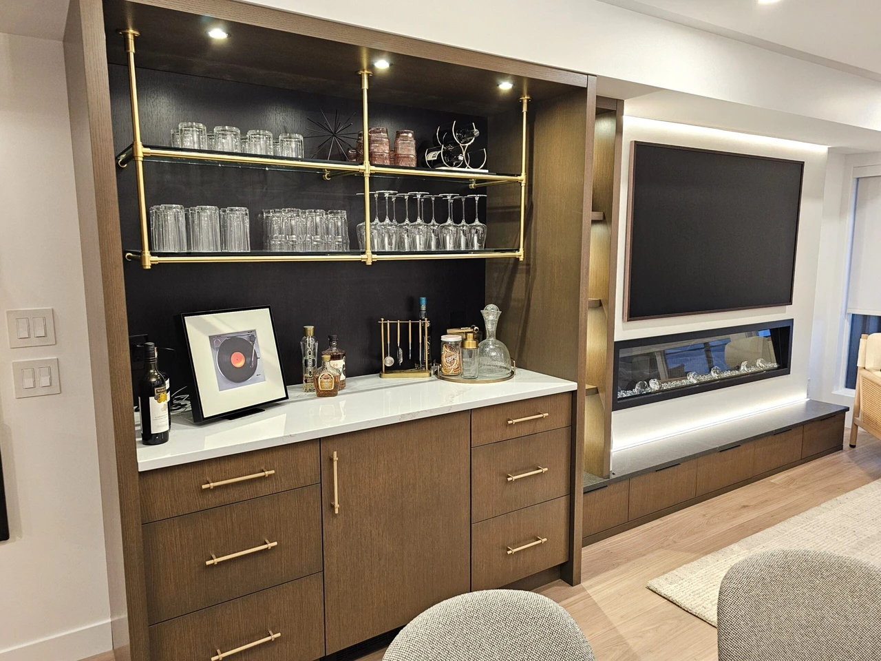 Stellar Craft Cabinetry Inc. custom bar cabinet with built-in wine glass shelving and countertop bottles