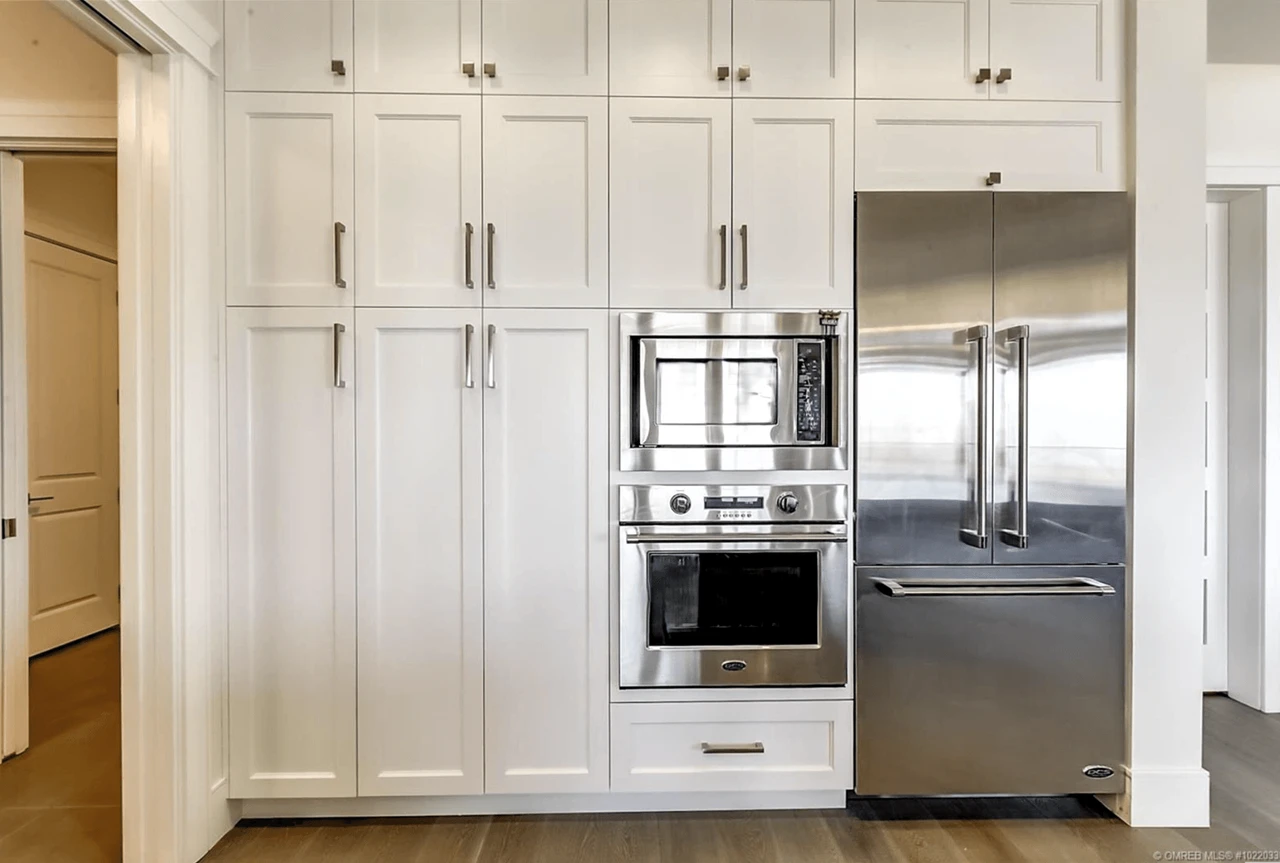 Stellar Craft Cabinetry Inc. white custom kitchen cabinetry with built-in oven and microwave