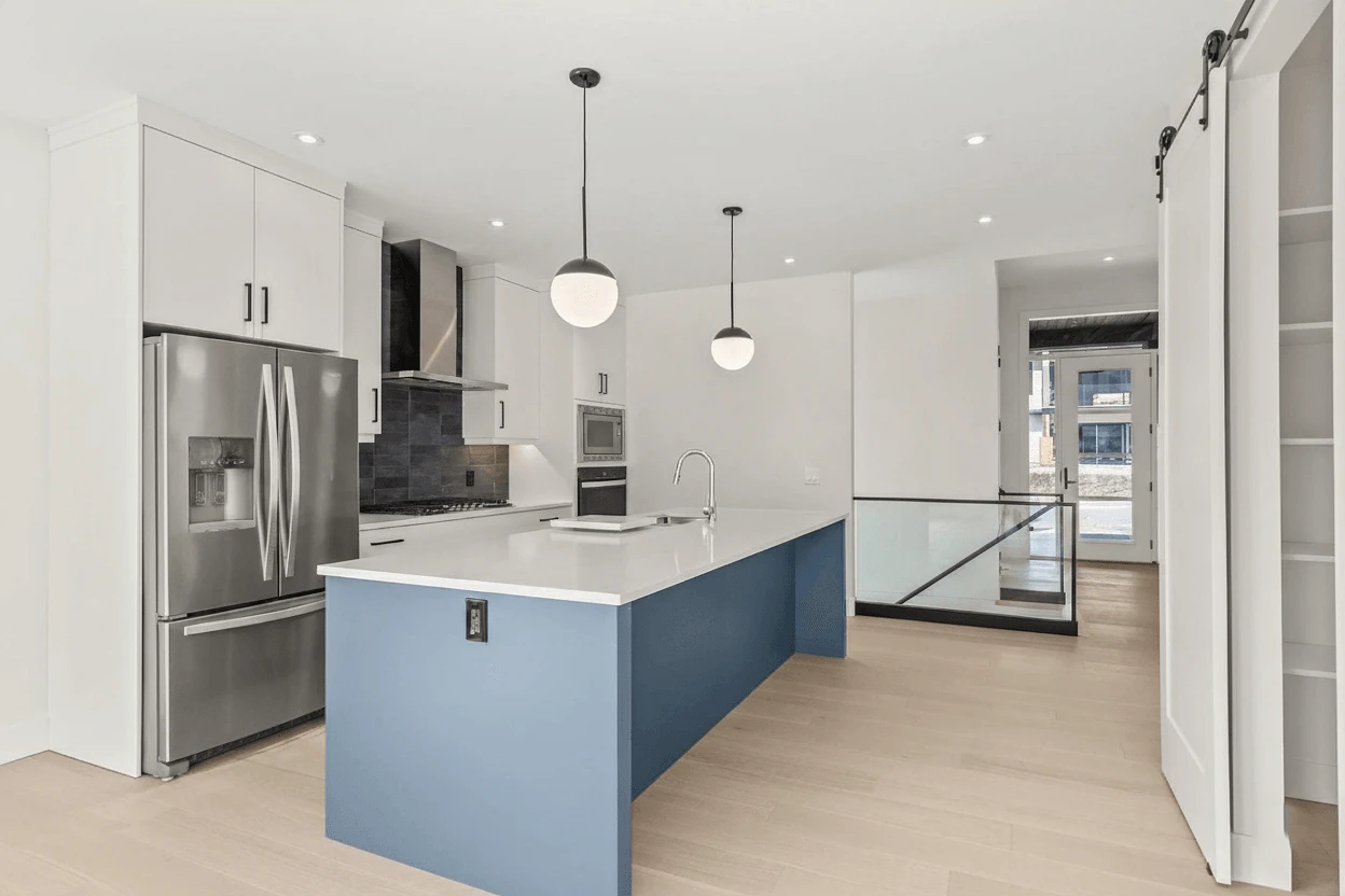 Stellar Craft Cabinetry Inc. modern kitchen with custom cabinetry, stainless refrigerator, and island