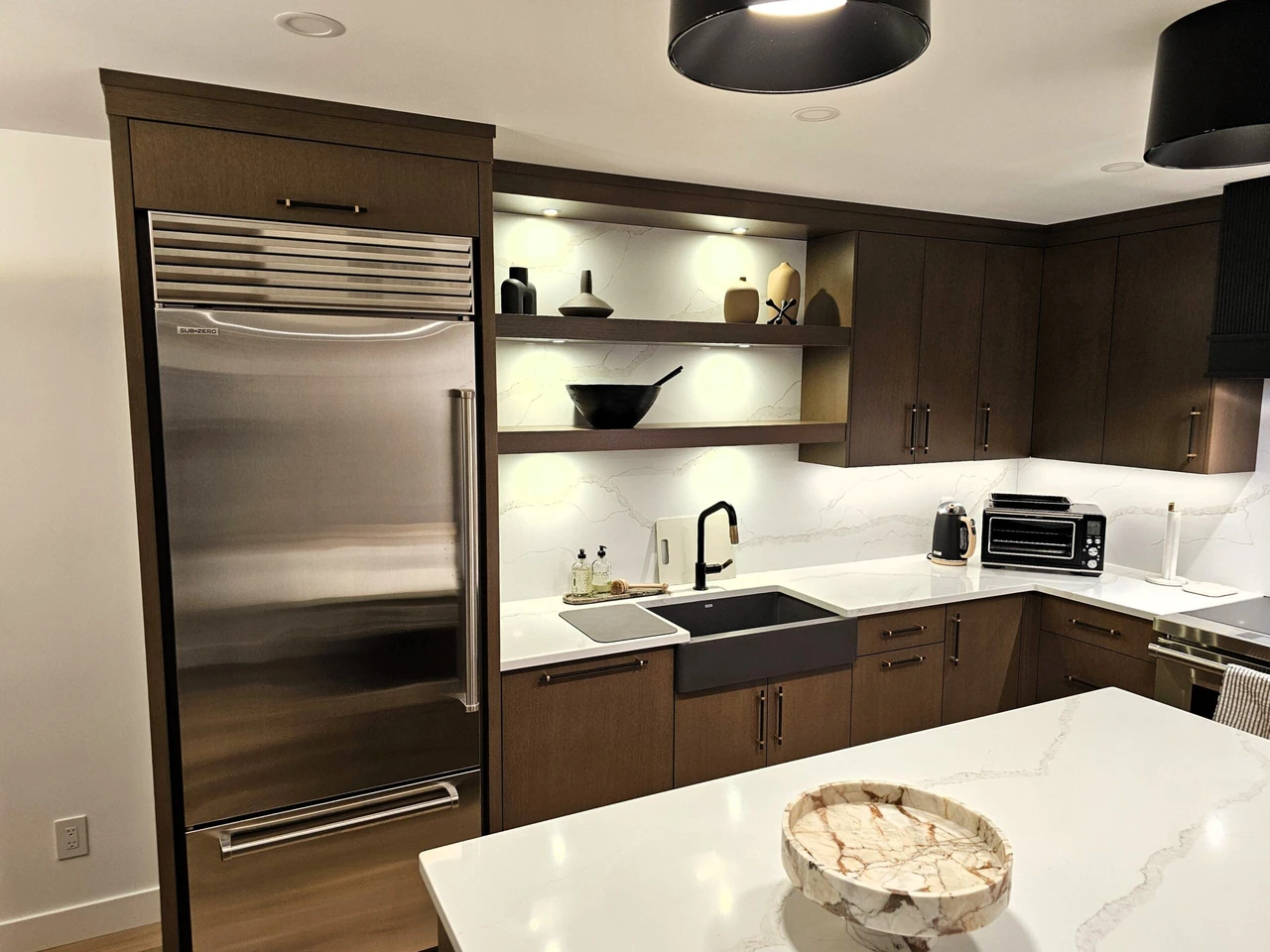 Modern custom kitchen with dark wood cabinetry, open shelves, built-in refrigerator, and quartz countertops by Stellar Craft Cabinetry Inc.