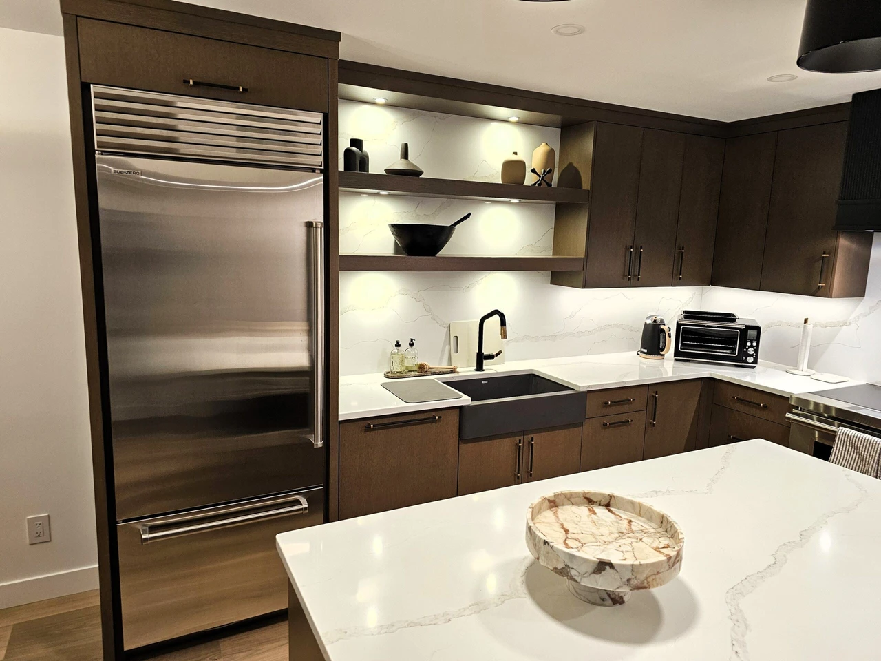 Stellar Craft Cabinetry Inc. modern kitchen with custom dark cabinetry, quartz countertops, and built-in refrigerator
