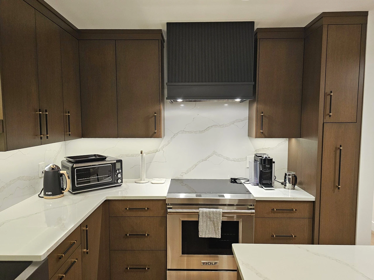 Stellar Craft Cabinetry Inc. modern kitchen with custom wood cabinetry, built-in range hood, and granite countertop