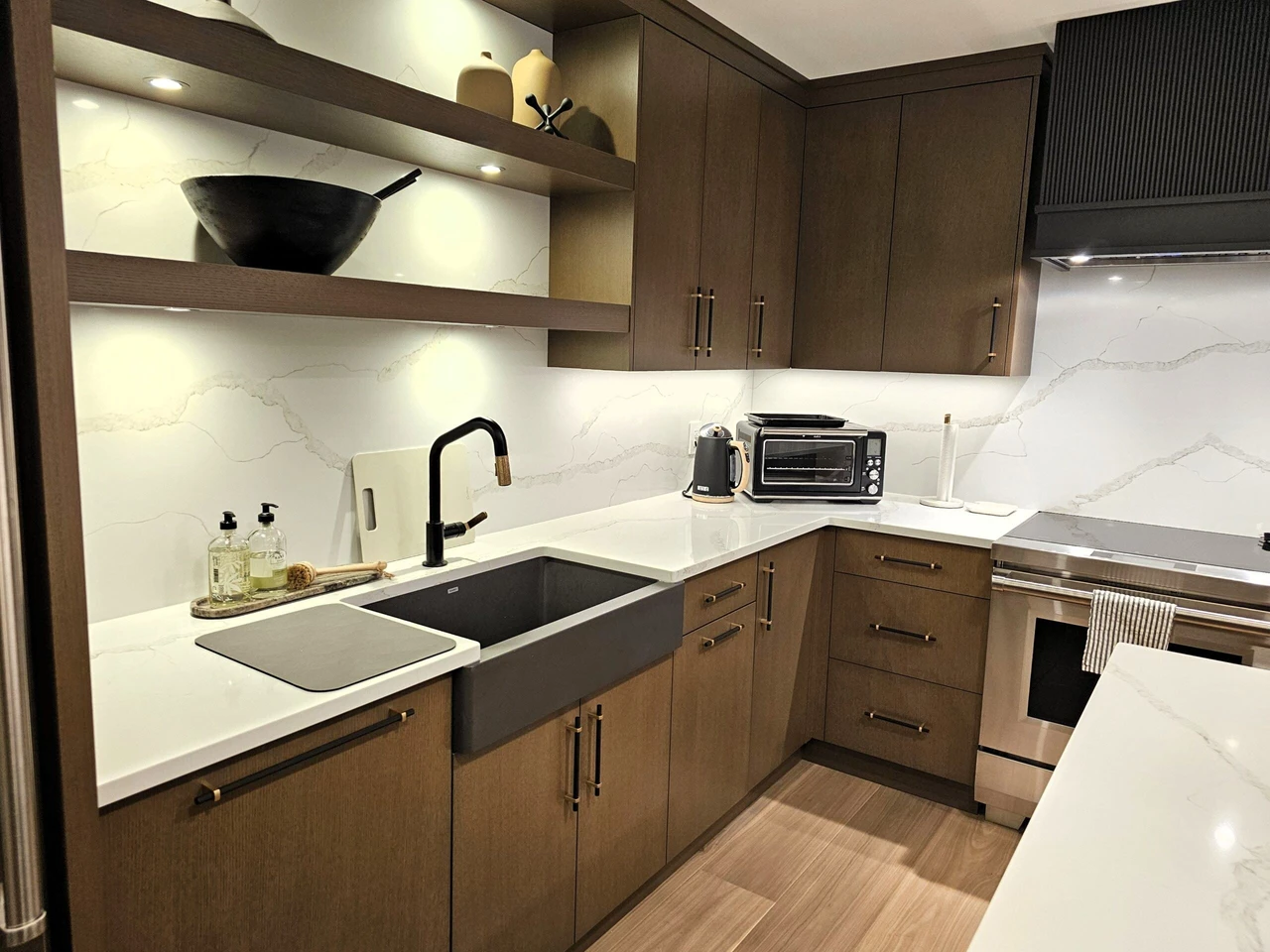 Stellar Craft Cabinetry Inc. modern kitchen with dark wood cabinets and white marble-look countertops