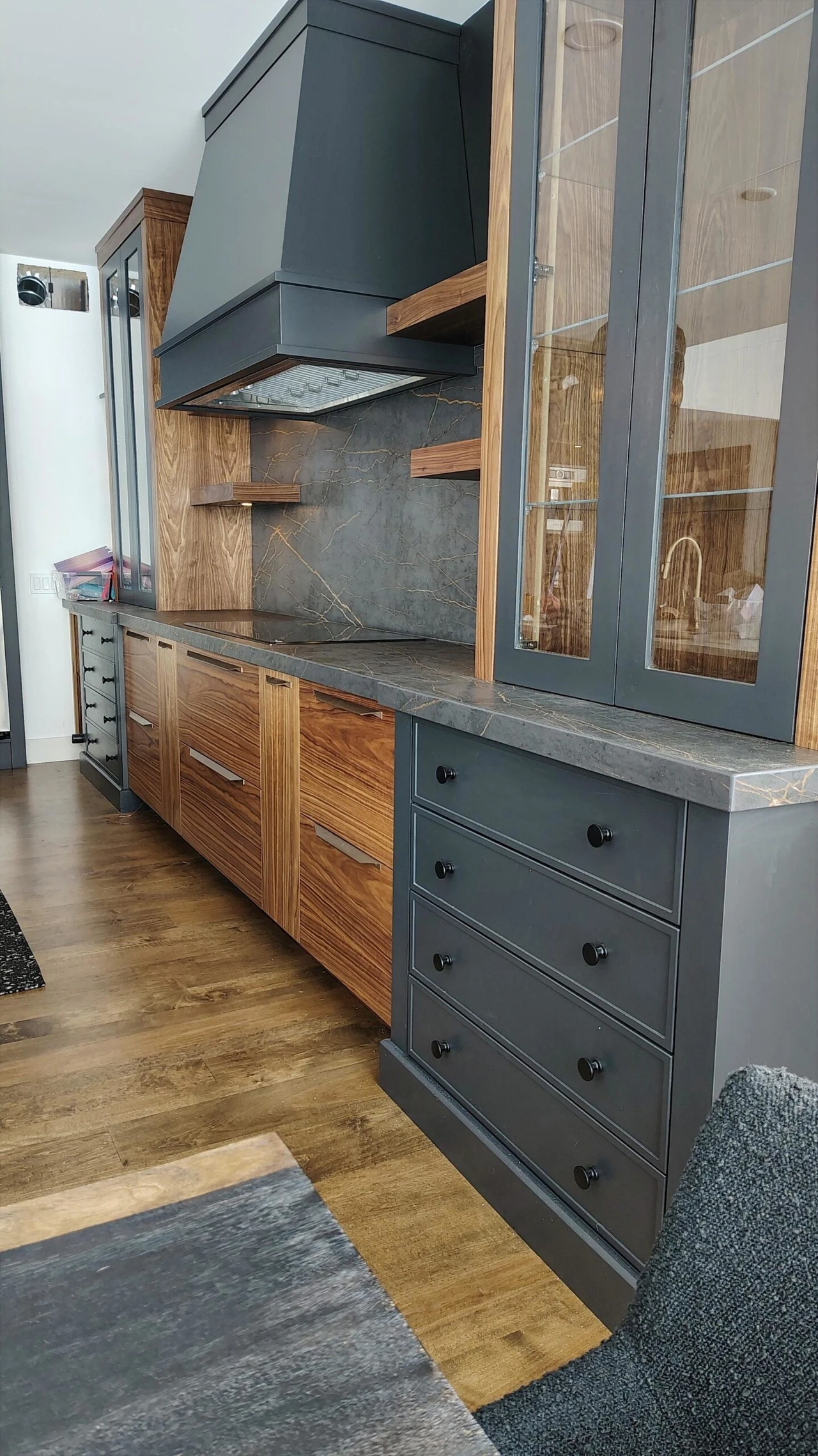 Stellar Craft Cabinetry Inc. custom kitchen cabinet and range hood with gray and wood finishes