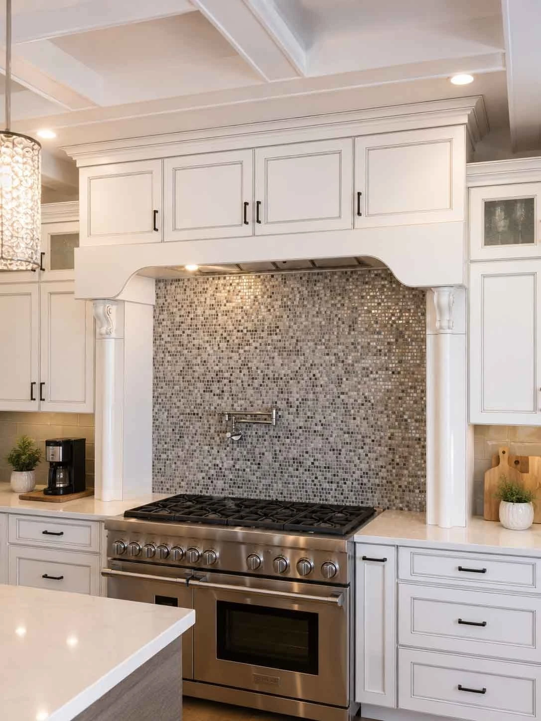 Stellar Craft Cabinetry Inc. custom white kitchen cabinets with mosaic backsplash and stainless range