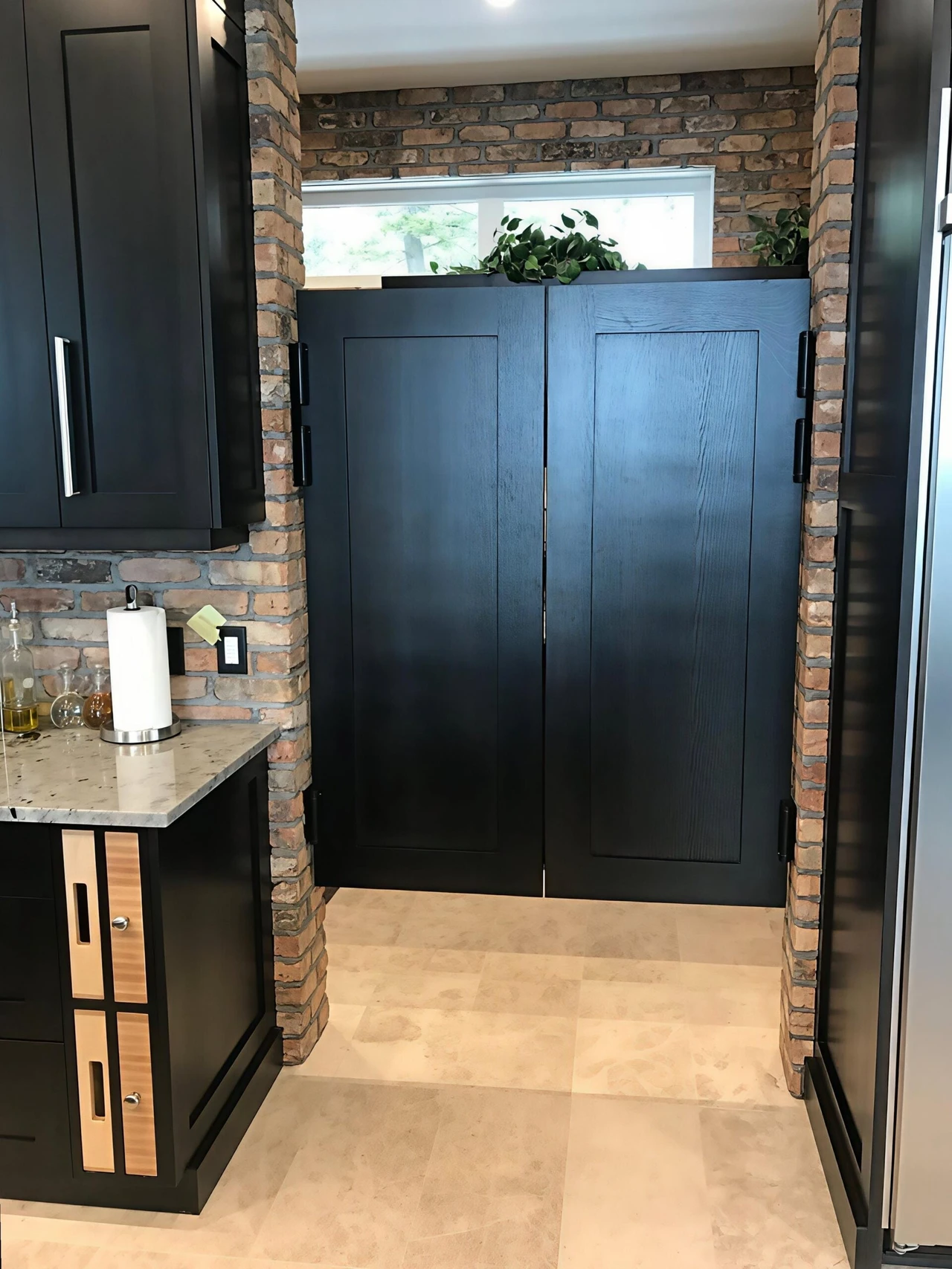 Stellar Craft Cabinetry Inc. dark wood custom cabinet installation with stone accent walls and black hardware
