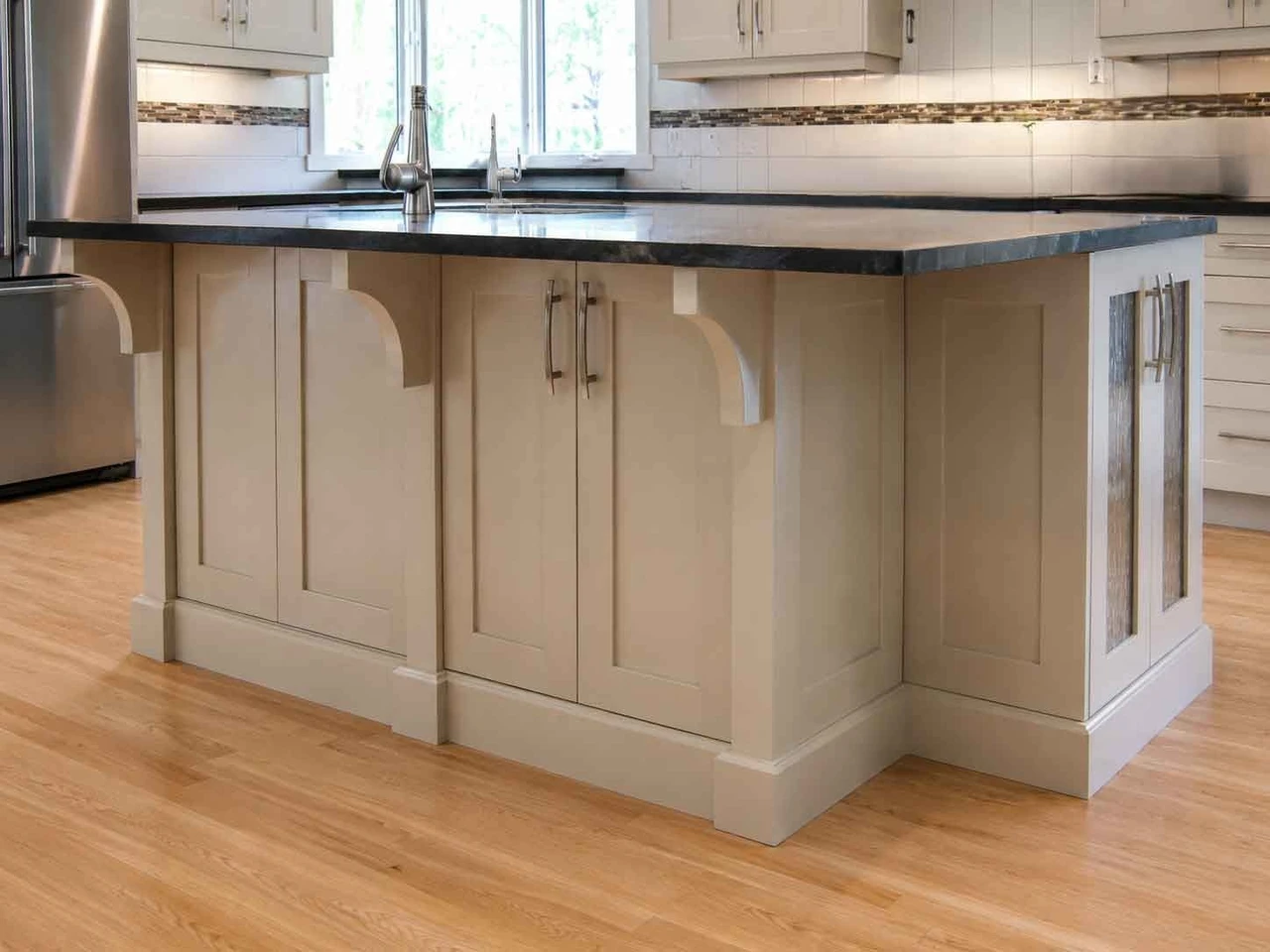 Stellar Craft Cabinetry Inc. custom white kitchen island with shaker cabinet doors and stainless sink